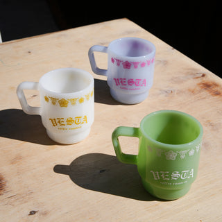 Three ceramic mugs with 'classic corningware' style print on a wooden surface.